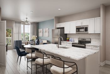 a kitchen and living room with a large island with a marble countertop
